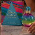 Britney Spears Festive Fantasy perfume bottle and packaging on a reflective surface.