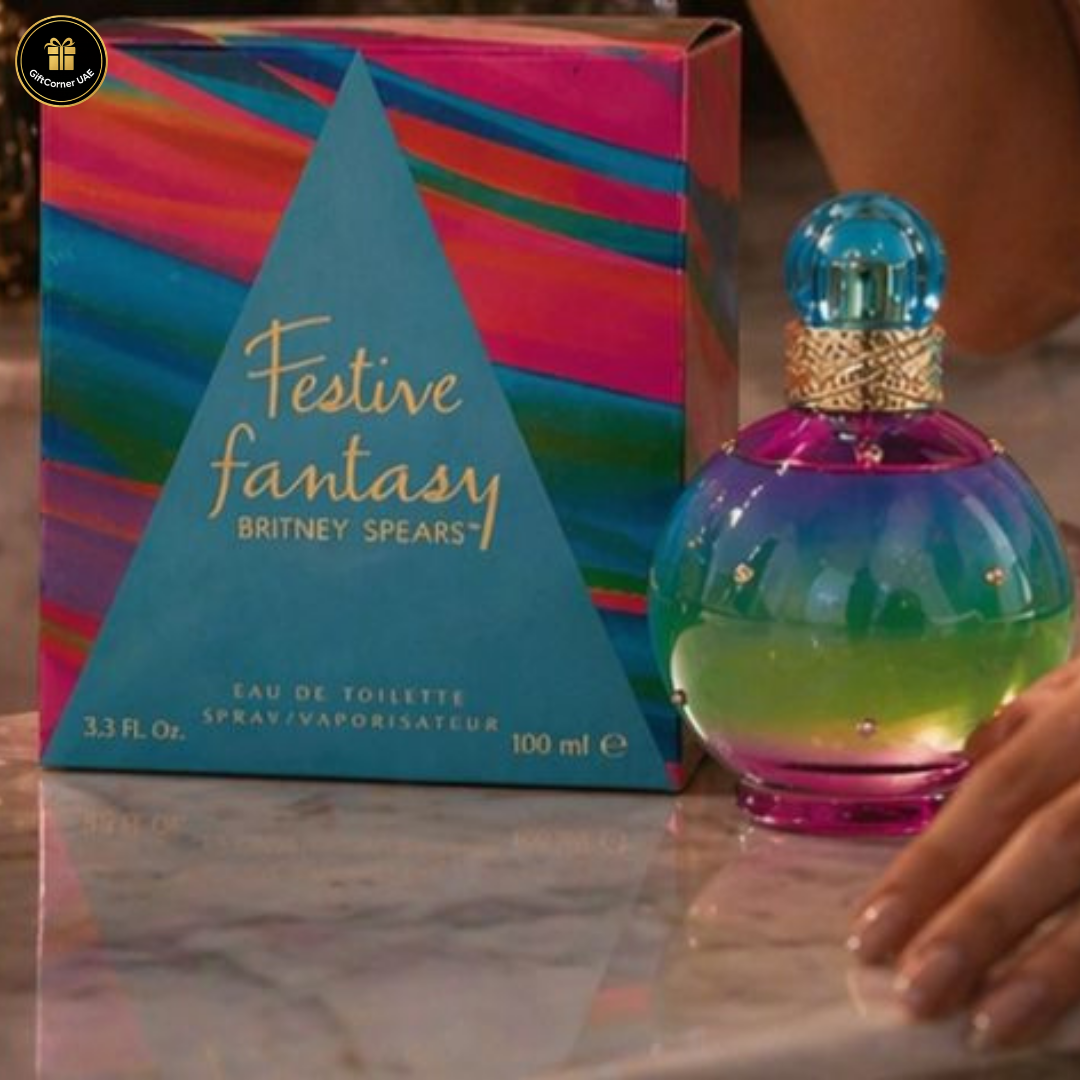 Britney Spears Festive Fantasy perfume bottle and packaging on a reflective surface.