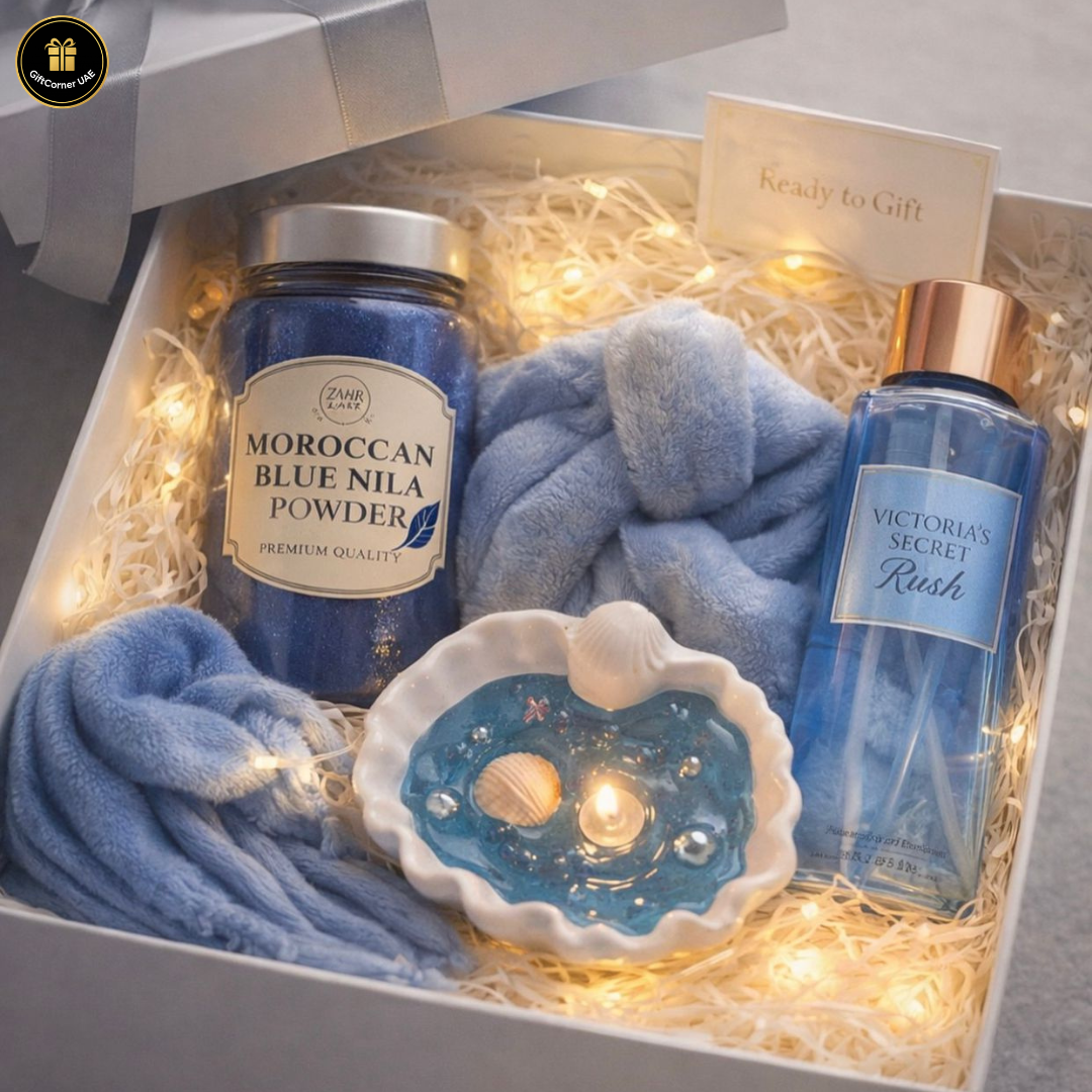Gift set with Moroccan Blue Nila Powder, towel, candle, and Victoria's Secret product in a decorative box.