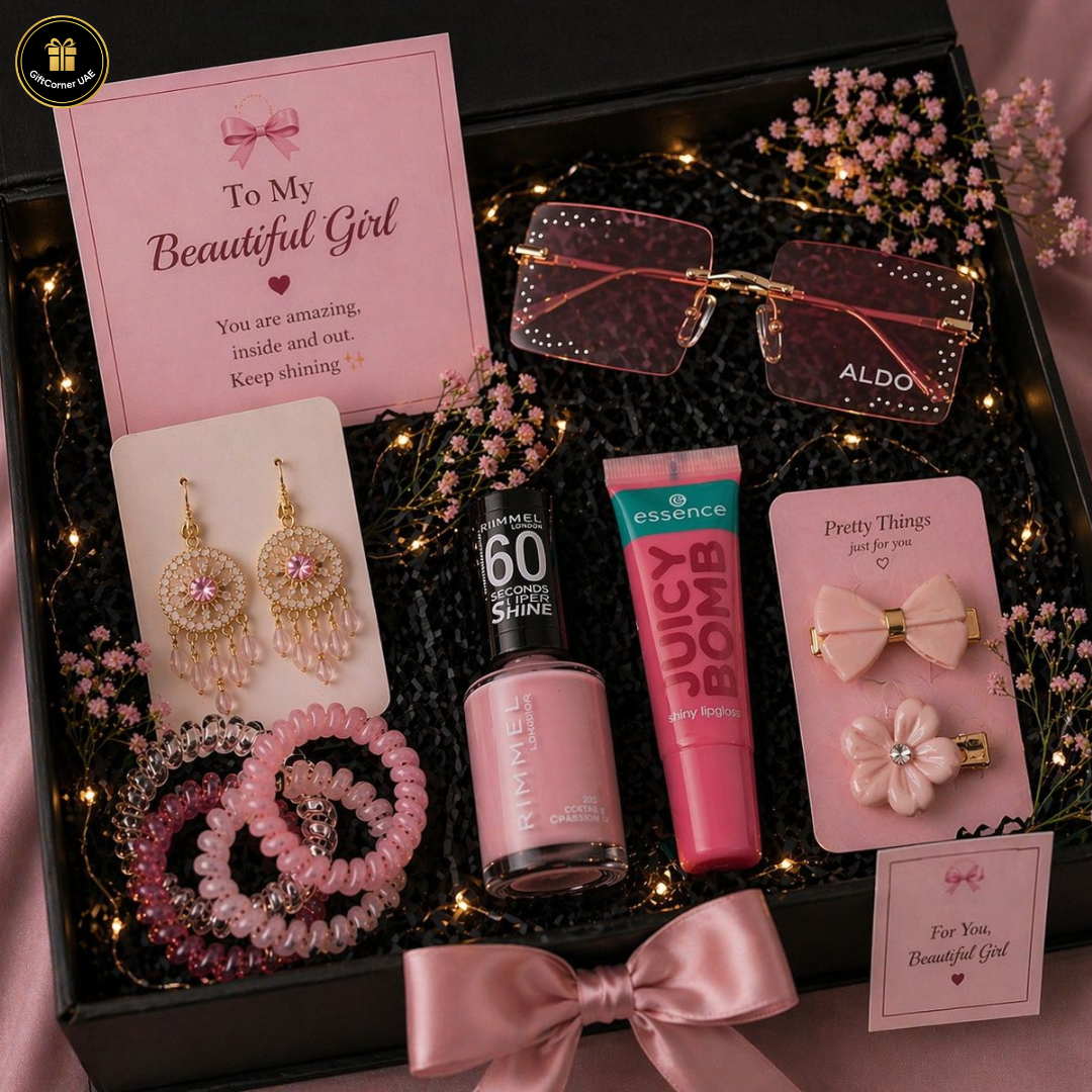 Gift set with pink accessories and nail polish on a dark surface with decorative lights and flowers.