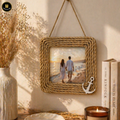 Rustic rope-framed photo of a couple on a beach, hanging on a wall with decor items.