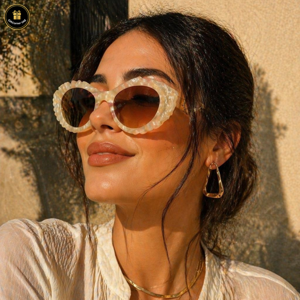 Woman wearing large, round sunglasses with a textured wall background