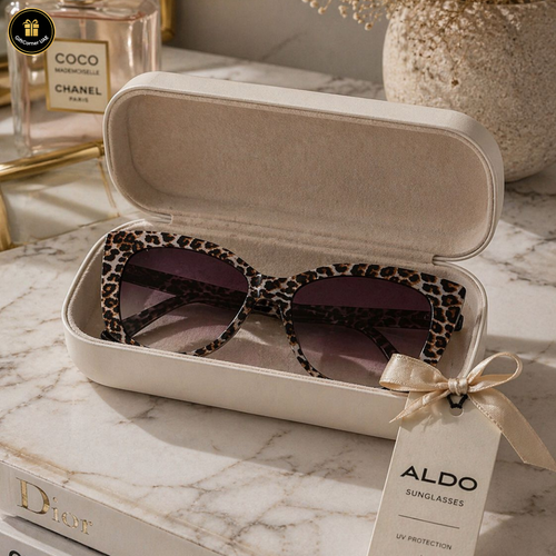 Leopard print sunglasses in a beige case with an Aldo tag on a marble surface.