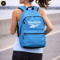 Person wearing a blue Reebok backpack outdoors