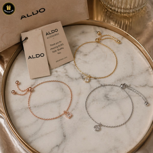Three bracelets on a marble surface with ALDO packaging.